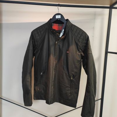 une veste en cuir noir accrochée à un porte-manteau dans une pièce