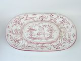 an old red and white platter with a bird and flowers design