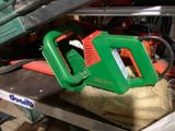 une tronçonneuse verte et orange posée sur une table