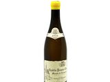 the bottle of wine is sitting on a white surface