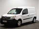 La camionnette blanche est garée dans une pièce au sol noir.