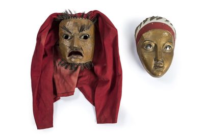 deux masques en bois recouverts d'un tissu rouge et un autre avec un foulard rouge