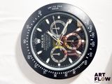 une montre noire et dorée posée sur une surface blanche