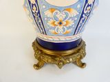 a blue vase with a gold base on a white background