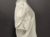 a white dress on a mannequin stand against a black wall