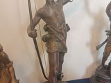 several bronze statues of a man holding a bow and arrow
