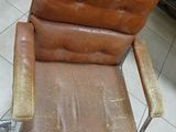 a brown chair that is sitting on a tile floor