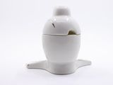 a white ceramic teapot with a lid on a white surface