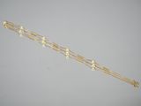 a gold chain bracelet with pearls and pearls on it