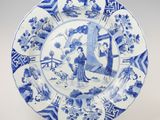 assiette bleue et blanche représentant une femme et un homme dans un jardin