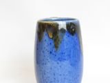 a blue cup with a brown rim sitting on a white surface