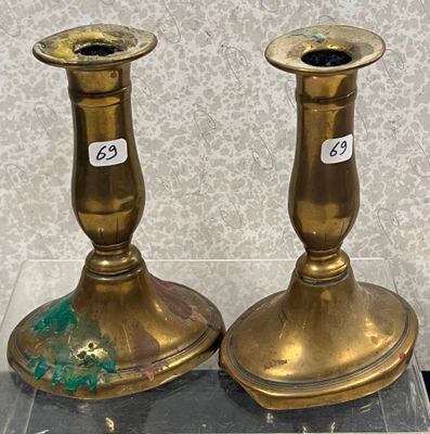 deux bougeoirs en or posés sur une vitrine transparente