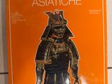 un livre orange sur lequel figure l'image d'un guerrier asiatique