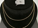 a black hat with a gold chain necklace on top of it