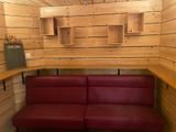 a red couch in the corner of a wooden room