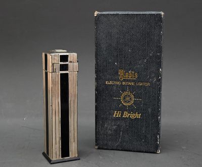 un vieux livre et un briquet posés l'un à côté de l'autre sur une table