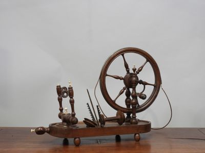 un rouet en bois posé sur une table, avec des bougies