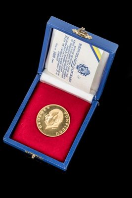 une médaille d'or dans un cadre bleu sur fond noir