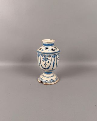 un vase bleu et blanc posé sur une surface grise