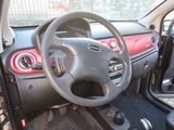 dashboard of a small car with a steering wheel and a dash light