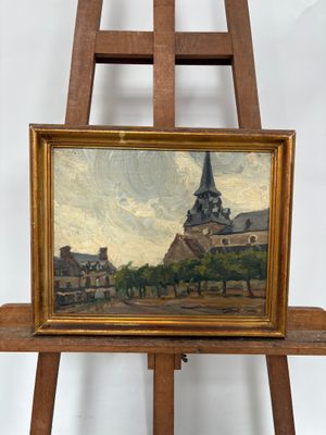 une peinture à l'huile représentant une église avec un clocher, posée sur un chevalet en bois