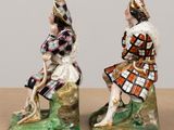 two figurines of a man and a woman sitting on a rock