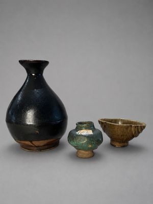 trois petits vases posés l'un à côté de l'autre sur une table