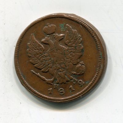 an old coin with a bird on it sitting on a white surface