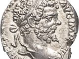 a silver coin with a head of a man wearing a crown