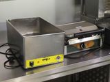 un plan de travail en acier inoxydable sur lequel sont posés une friteuse et une poêle