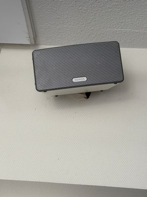 une enceinte noire et blanche posée sur une surface blanche