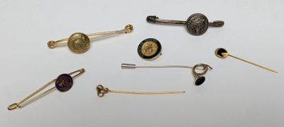 many different types of pins and brooches on a white surface