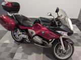 une moto rouge et noire garée sur un sol à damier