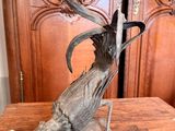 une statue représentant un oiseau posée sur une table en bois