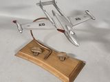 a silver model of a plane on a wooden stand