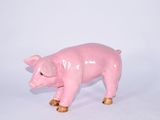 une petite figurine de cochon rose sur une surface blanche
