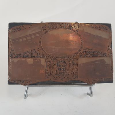 un étui en cuir marron orné d'images, posé sur un support métallique