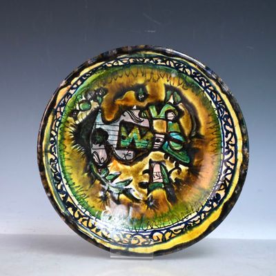 une assiette avec une peinture posée sur une table