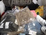 a pile of clothing and a skateboard on the floor