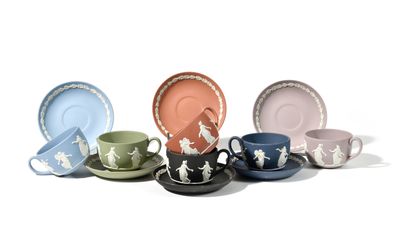 several cups and saucers are lined up on a white surface