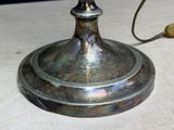 a silver plate with a candle on it on a table