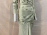 the mannequin is wearing a green dress with long sleeves