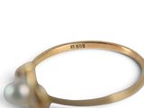 a close up of a ring with a pearl on a white background