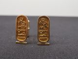 two gold cufflinks with the words love and peace engraved on them