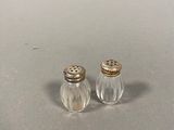 two salt and pepper shakers sitting on top of a table