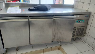 a stainless steel counter top in a kitchen with a window
