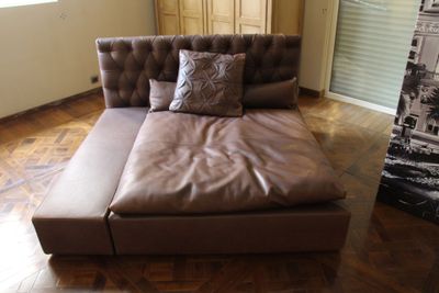 un canapé en cuir marron orné de coussins, dans un salon