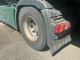 a green semi truck parked on the side of the road