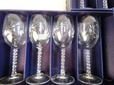 four wine glasses in a box with a chain around them