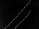 a close up of a gold necklace on a black background